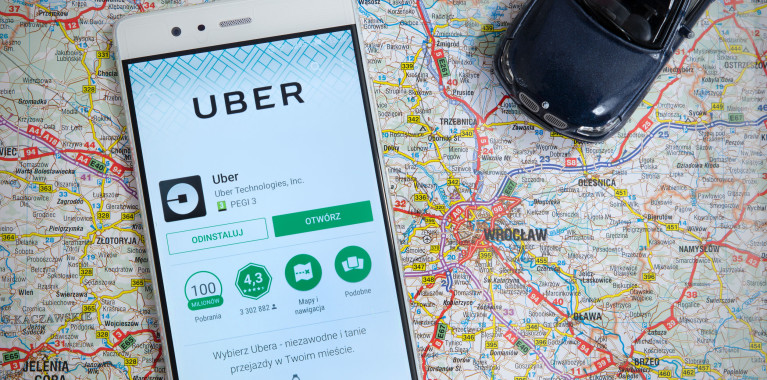 Is Uber Dangerous to Women, smartphone with Uber app on a map of a city